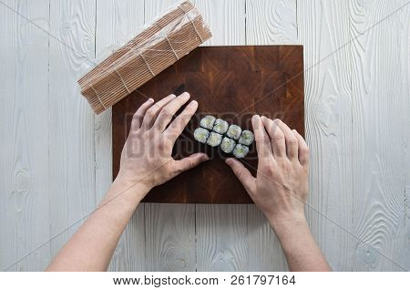 Process Of Making Maki Sushi. Cook Chef Hands Preparing Rolls With Cheese, Avocado And Sesame Seeds 