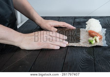 Process Of Making Maki Sushi. Cook Chef Hands Preparing Rolls With Cheese, Avocado And Sesame Seeds 