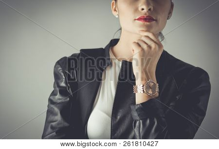Portrait Of Beautiful Young Brunette Woman In Stylish Black Jacket On Gray.