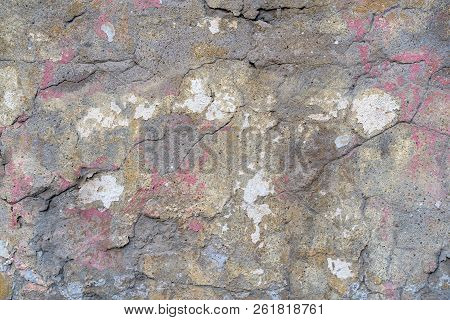 Old Plastered Brick Wall With Cracks And Traces Of Paint