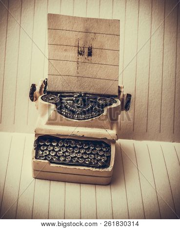 Retro Syled Tiny Typewriter Model On A Paper Background