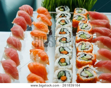 Fresh Sushi, Sushimi And California Rolls On A Glass Tray