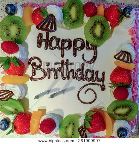 Closeup Of Face On View Of A Cream And Friuit Birthday Cake.  Shot Taken Looking Directly Down At Th