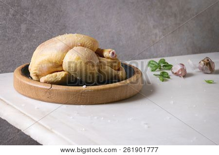 Raw Organic Uncooked Whole Yellow Corn Mini Chicken On Wooden Cutting Board With Salt, Herbs And Gar