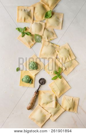 Homemade Raw Uncooked Italian Pasta Ravioli Staffed By Spinach Ricotta, Basil Leavrs, Pasta Cutter. 