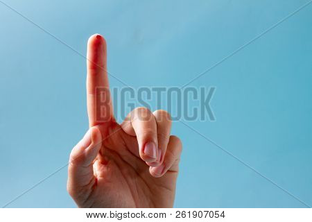 Finger With Blood Drop On Blue Background