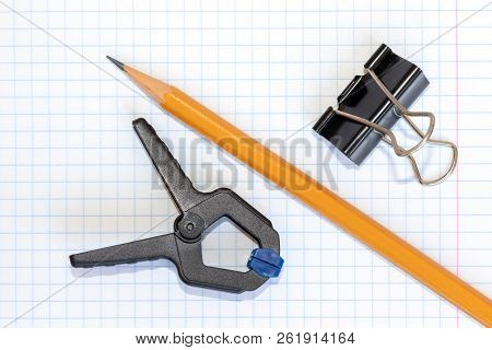 Yellow Wooden Pencil, Clip And Grip On Checkered Exercise Book Paper, Diy And Craft Concept.