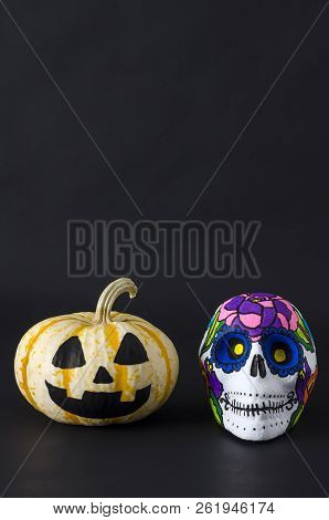 Little Pumpkin And Styrofoam Skull With Flowers For Halloween And Mexican Day Of The Dead Against Bl