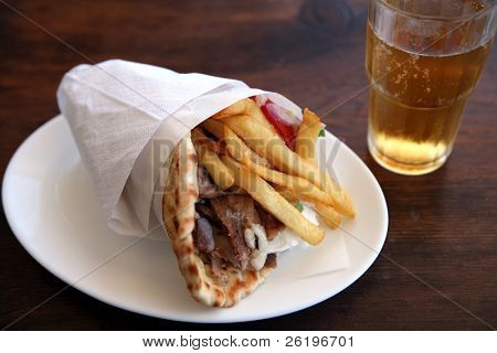 Un gyros de pita souvlaki, le standard grec kebab ou viande wrap, avec frites, yaourt et salade et un