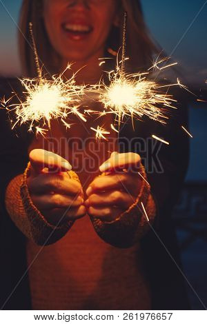 Close-up Of Happy Woman With Bright Bruning Sparklers In The Night