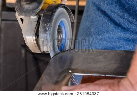 Heavy Industry Worker Cutting Steel With Angle Grinder At Car Service