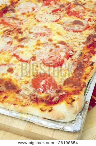 Pizza rettangolare con formaggio e pomodoro condimento su una teglia da forno, o il modo tradizionale siciliana