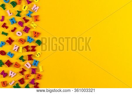 Multicolored Alphabet Background. Colorful Letters Of The English Alphabet Are Scattered On Yellow B
