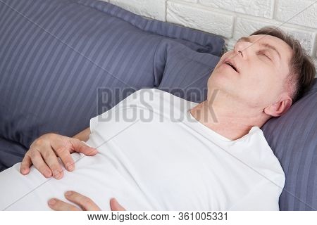 Man Snoring Because Of Sleep Apnea Lying In The Bed