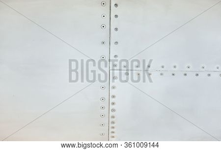 Silver Metal Surface Of The Aircraft Fuselage With Rivets. Fuselage Detail View. Airplane Metallic F