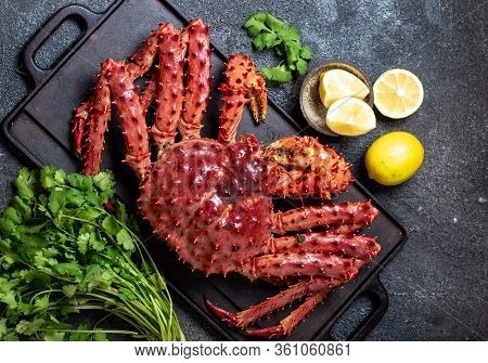 King Crab With Lemon And Cilantro On Black Background. Top View
