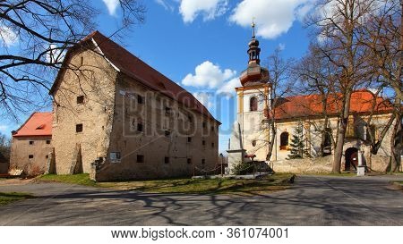 Kadov / Czech Republic - April 10, 2020: Gothic church of St. Wenceslas from the second half of the 13th century and castle in medieval village Kadov in Southern Bohemia.