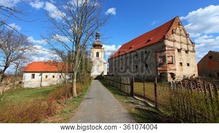 Kadov / Czech Republic - April 10, 2020: Gothic church of St. Wenceslas from the second half of the 13th century and castle in medieval village Kadov in Southern Bohemia.