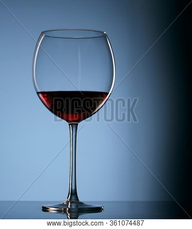 Elegant photo of a glass of red wine on dark background.