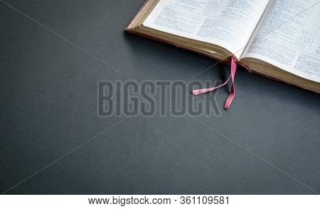 Top View Of Open Holy Bible  On The Black Color Table. Space Fpr Text.