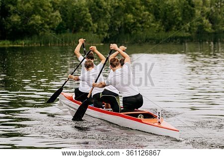 Four Man Athletes Canoeist Paddling In Canoe On Lake