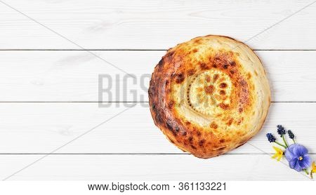 Tasty Fresh Round Tandoor Bread On A White Wooden Background. Flat Lay With Copy Space For Text Or R