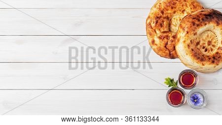Two Freshly Baked Cake - Tandoor Bread On A White Wooden Background, Next To Glasses Of Armudu With 
