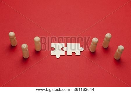 Wooden Figures With Pazzles On Red Background. Agreement Between Business Mans, Cooperation And Deal