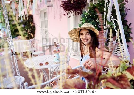 Attractive Woman Is Relaxing In The Outdoorcafe Veranda. Summertime.