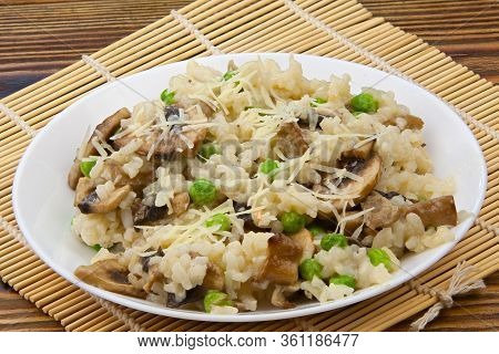 Tasty Appetizing Risotto On A White Plate On A Wooden Background