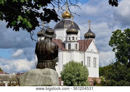 Belarus, Smorgon, August 2019. The Monument To The Belarusian Poet Bogushevich Faces The White Churc