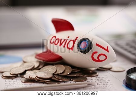Rocket With Inscription Covid 19 Fell On A Pile Of Coins Close-up Background. World Financial Crisis
