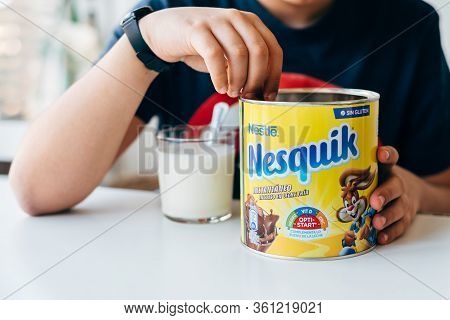 Madrid, Spain - April 1, 2020: Boy Serving Nesquik Cocoa Powder In A Glass Of Milk. Nesquiq Is A Tra