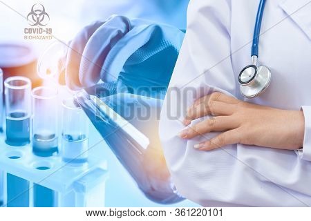 Doctor And Microbiologist With Vacuum Tubes For Samples With Covid-19 Coronavirus Chinese Infection