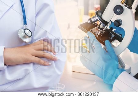 Doctor And Microbiologist With Vacuum Tubes For Samples With Covid 19 Infection Atypical Pneumonia V