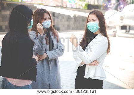 Three Confident Businesswomen Talking And Wearing Face Protection In Prevention For Coronavirus In P