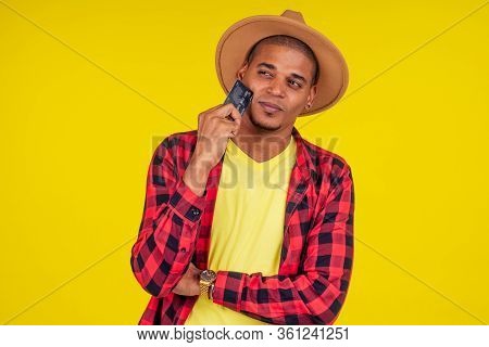 Afro Brazilian Man With Credit Card In Stusio On Yellow Background.farmer Taking A Loan In A Bank Fo