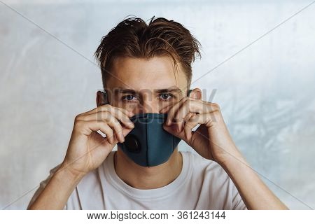 A Young Man Puts On A Protective Mask With A Filter