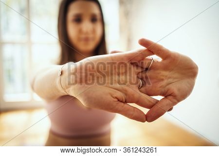 Young Woman Is Doing Yoga Meditation In The Living Room At Home. She Is Meditating On Floor Mat In M