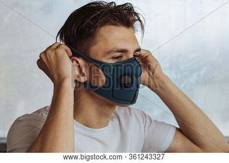 A Young Man Puts On A Protective Mask With A Filter