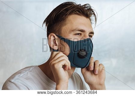 A Young Man Puts On A Protective Mask With A Filter