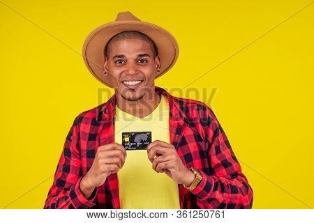 Afro Brazilian Man With Credit Card In Stusio On Yellow Background.farmer Taking A Loan In A Bank Fo