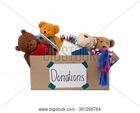 Brown Cardboard Box Filled With Soft Toys, School Supplies On White Background, Concept Of Charity A