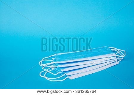 Protective Surgical Ear-loop Masks On Blue Background.