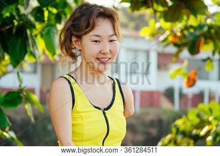 Happy Asian Armless Woman Warming Up Before Swimming At The Tropical Beach