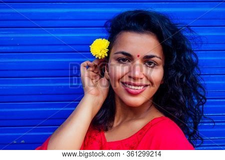 Attractive Beautiful Happy Young Latin Hispanic Woman With Teak Bindi On Forehead Smiling On Blue Wa