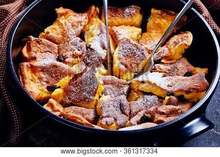Light And Fluffy Austrian Pancake Kaiserschmarrn With Raisins And Icing Sugar On Top, Cutlery On A B