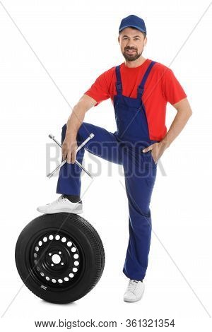Full Length Portrait Of Professional Auto Mechanic With Lug Wrench And Wheel On White Background
