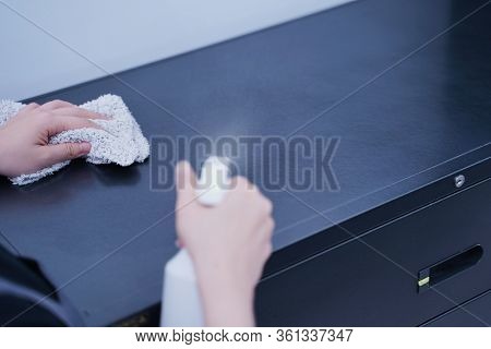 Young Woman Is Holding Spray Bottle, Rag To Clean, Wipe Down Office Metal Cabinet Shelf Accommodatio