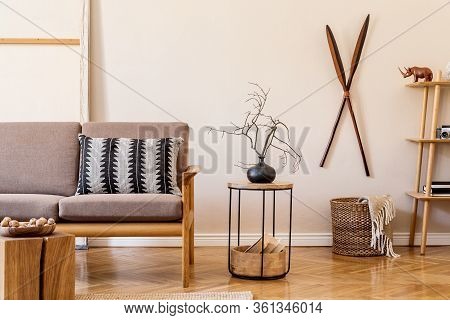 Interior Design Of Living Room With Stylish Brown Wooden Sofa, Macrame, Bookstand, Lamp, Coffee Tabl
